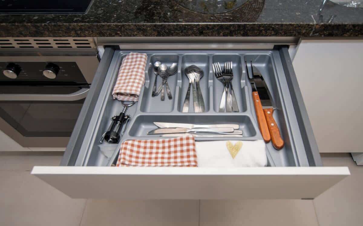 A kitchen drawer with utensils and a knife.