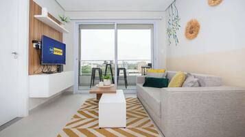 Una sala de estar moderna con un sofá, una mesa de centro y un televisor montado en la pared.