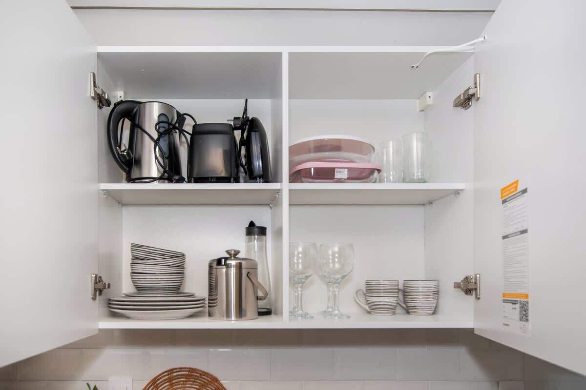 Un meuble de cuisine doté d’étagères où sont rangés les ustensiles de cuisine et la vaisselle.