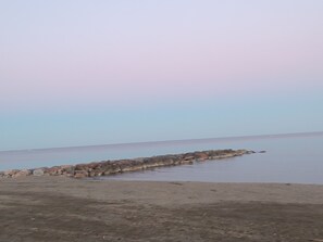 A coastal scene with a rocky breakwater extending into calm waters. - Beachfront apartment, very large terrace, pool, air conditioning, parking (Le Barcarès)