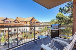 Ein Balkon mit Grill, Stühlen und Blick auf Wohnhäuser.
