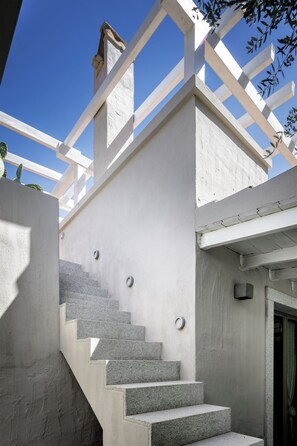 A staircase with white railings and a concrete wall. - House Among the Olive Trees (villasimius)