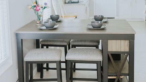 A modern kitchen with a central island, two bar stools, and a dining table. - Modern 2BR • Gated Parking • 10 Min to Downtown (Detroit)
