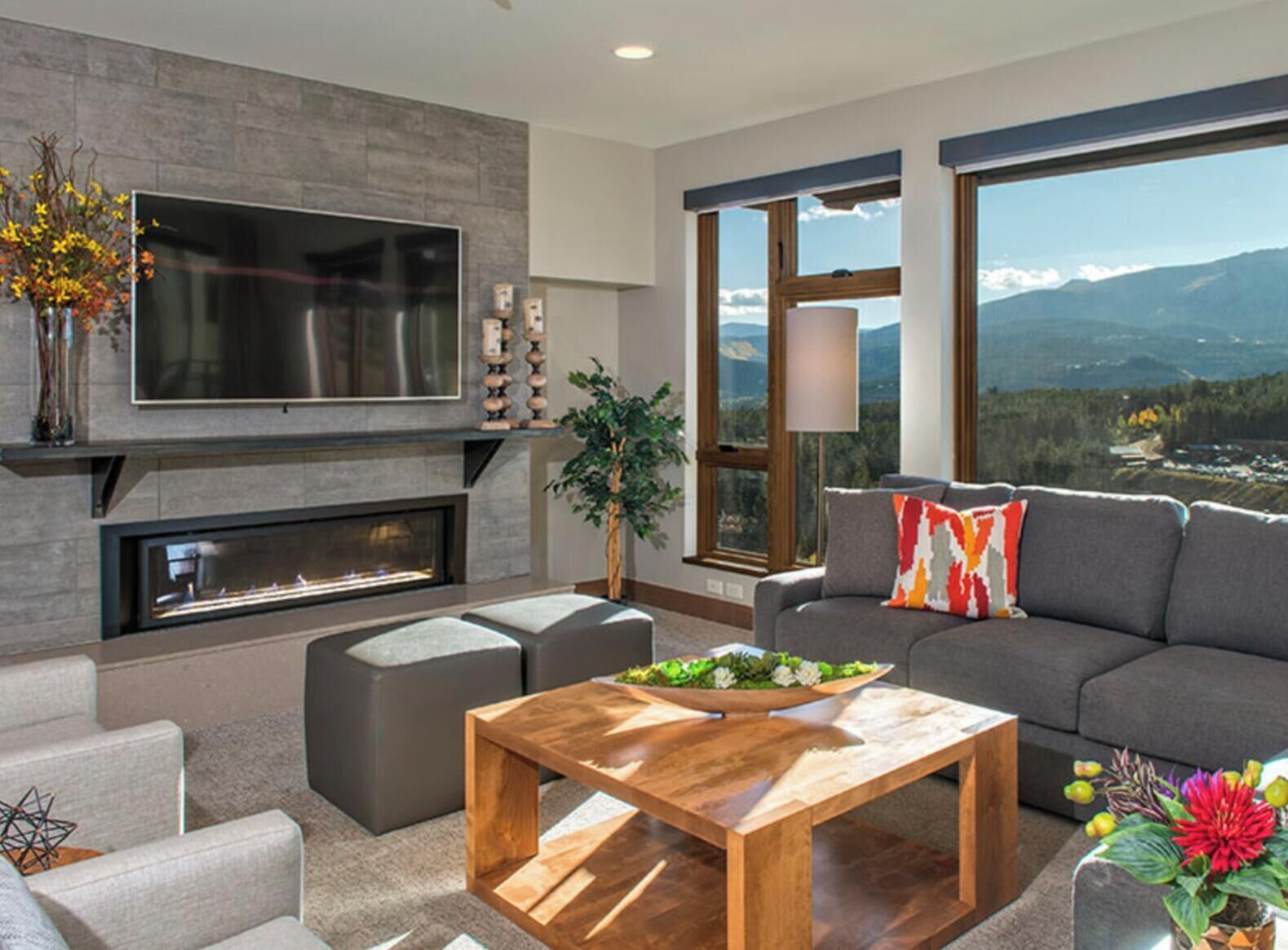 Una sala de estar moderna con chimenea, un televisor de pantalla plana grande, un sofá y una mesa de centro.