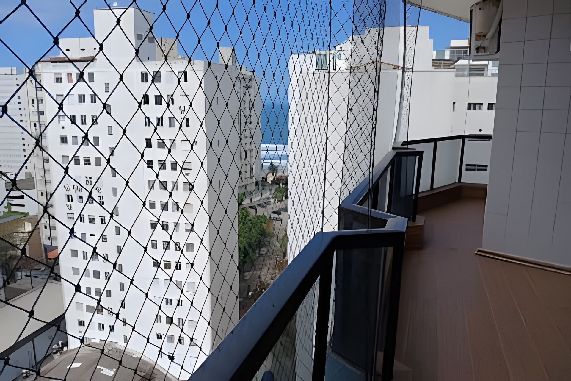 A high-rise building with a chain-link fence in the foreground.