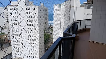 Un edificio de gran altura con una cerca de malla metálica en primer plano.