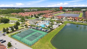 Zona residencial amb piscina, pistes de tennis i un llac.