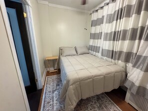Ein Schlafzimmer mit einem Bett, einem Nachttisch und einem gemusterten Teppich.