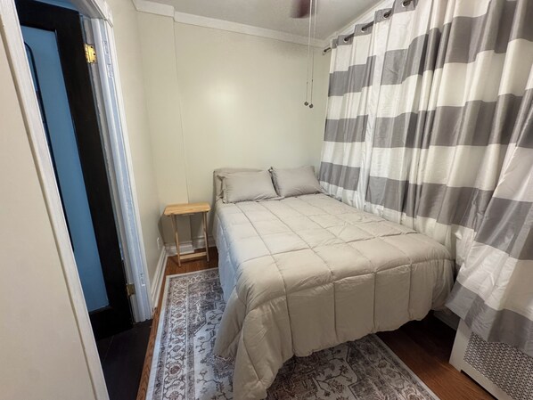 Une chambre à coucher avec un lit, une table de chevet et un tapis à motifs.