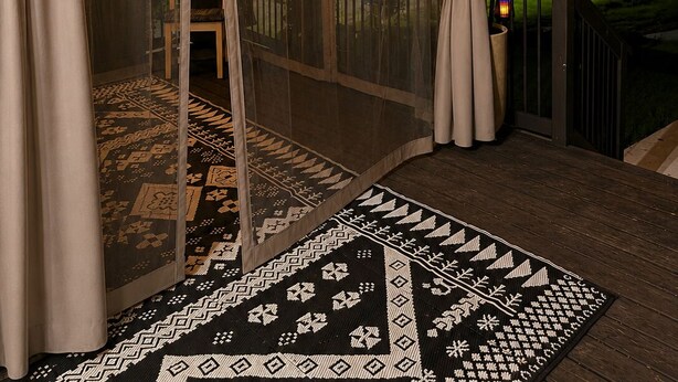 A covered outdoor seating area with string lights, a patterned rug, and a wooden deck. - 3BR House Near Mercedes Stadium Sleeps 8 w/ free Parking, A/C, Laundry, & Gazebo (Atlanta)