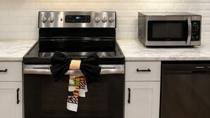 A kitchen with a stainless steel stove, oven, and microwave. - 3BR House Near Mercedes Stadium Sleeps 8 w/ free Parking, A/C, Laundry, & Gazebo (Atlanta)