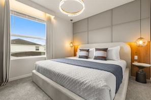 A hotel room with a large bed, a view of the outside, and a modern ceiling light. - 10 BD/ 8 BA/ Windsor Cay (1007 CR) (Clermont)