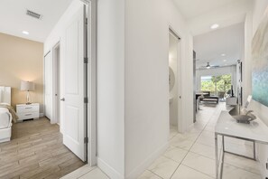 Un interior moderno con un pasillo que conduce a un comedor, un dormitorio y un baño.