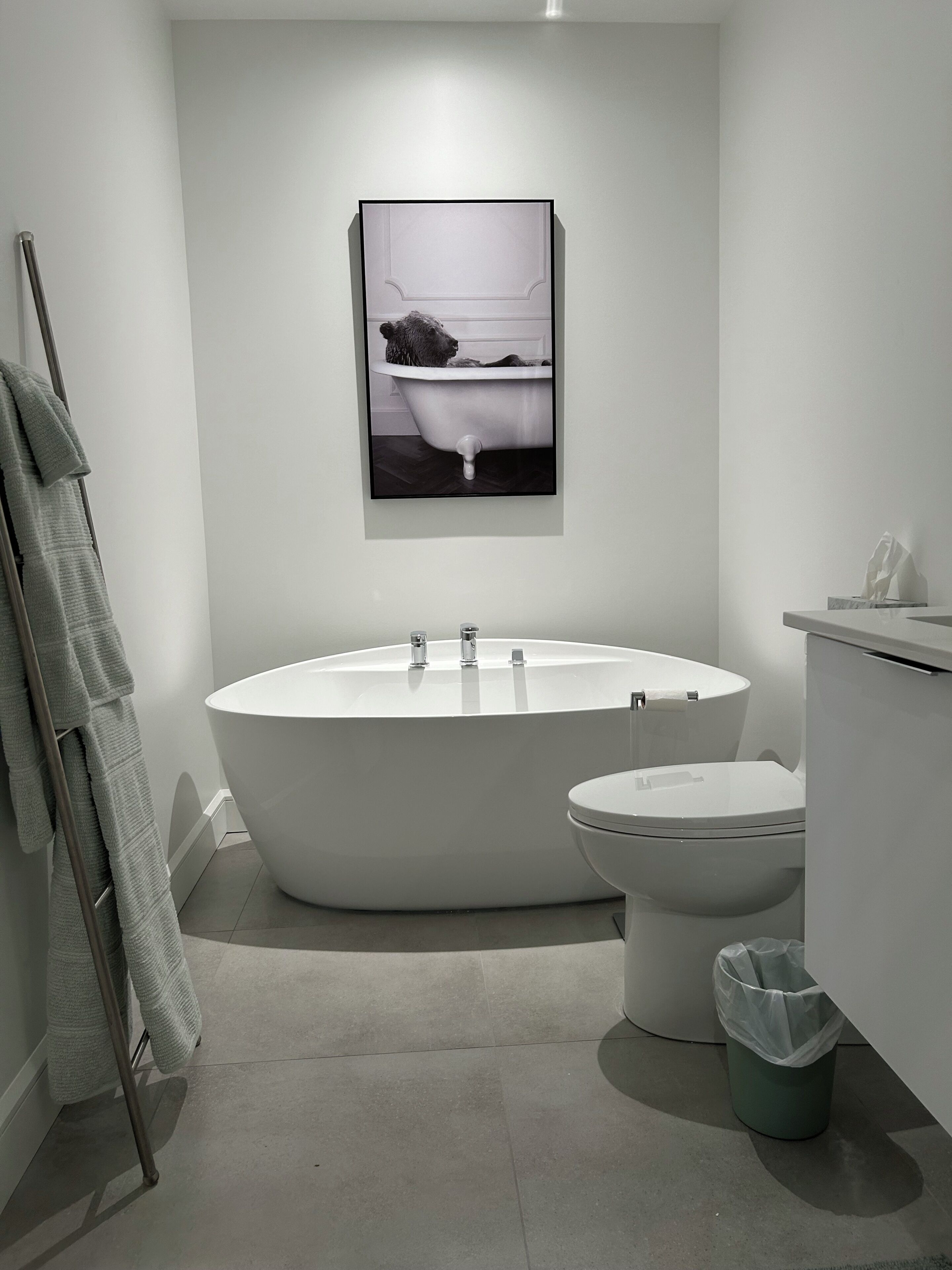 A modern bathroom with a freestanding bathtub, a toilet, and a towel rack.