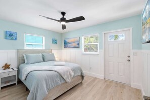 A bedroom with a bed, nightstand, and a ceiling fan. - Resort Style | Golf Cart, Spa, Beach Shack, Kayaks (Indian Rocks Beach)