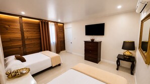 A hotel room with two beds, a dresser, a TV, and a mirror. - Villa la Santa, Higüey - La Altagracia (Higüey)