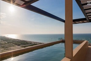 A pool with a view of the sea and a distant shoreline.