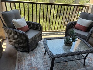 A balcony with wicker furniture, a glass table, and a potted plant. - Relaxing 2BR Desert Ridge Retreat Near Mayo Clinic with Resort Style Amenities (Phoenix)