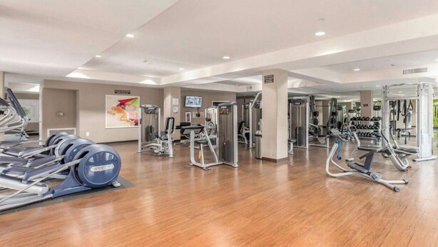 Ein Fitnessstudio mit Laufbändern, Kraftgeräten und Kurzhanteln.