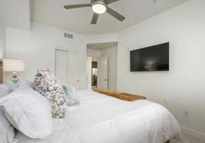A bedroom with a bed, a ceiling fan, a TV mounted on the wall, and a door leading to another room. - Relaxing 2BR Desert Ridge Retreat Near Mayo Clinic with Resort Style Amenities (Phoenix)