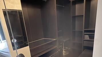 Ein modernes Badezimmer mit einer schwarzen Badewanne, einer Duschkabine aus Glas und einem Waschtisch mit Spiegel.