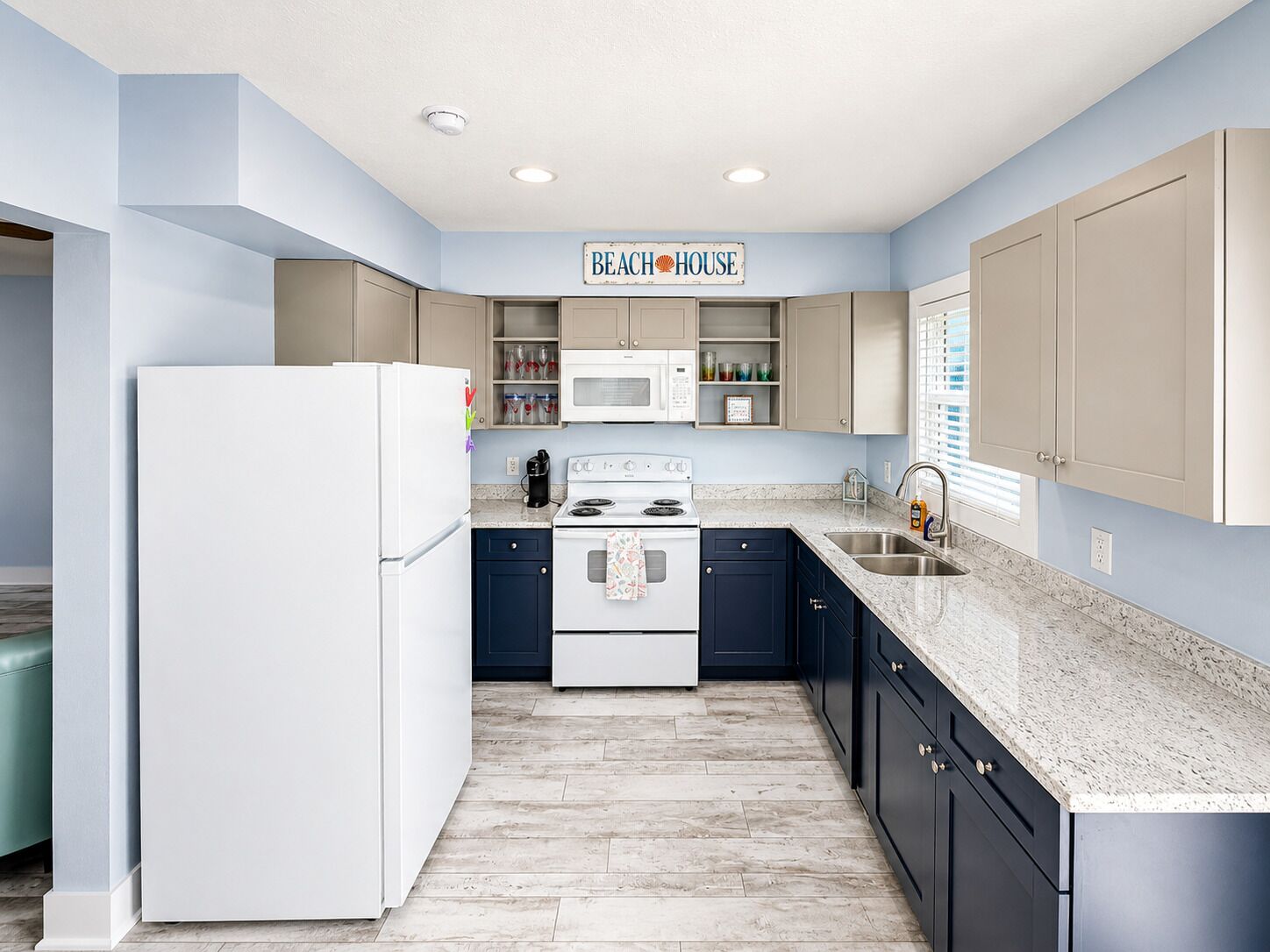 A kitchen with a white refrigerator, a microwave, a stove, and cabinets.
