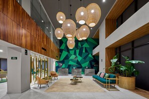 A modern lobby with a geometric wall design, a central seating area with a sofa and chairs, and a coffee table. - King Room w/ Breakfast | Pool Near Paseo Montejo (Mérida)