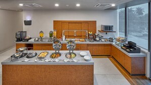 Una moderna colazione a buffet con diverse opzioni alimentari e una macchina per il caffè.