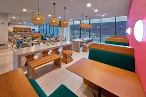 A modern restaurant with wooden tables and benches, large windows, and hanging spherical light fixtures. - King Room w/ Breakfast | Pool Near Paseo Montejo (Mérida)