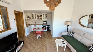 Un appartement moderne comprenant un salon, une cuisine et un coin repas.