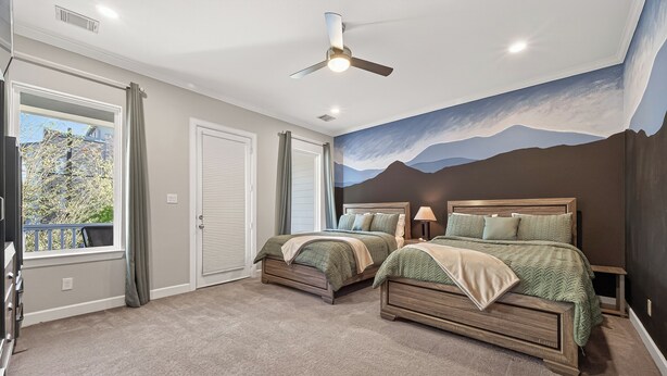 Ein Schlafzimmer mit zwei Betten, einem Deckenventilator und einer Wandmalerei von Bergen.