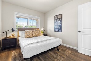 Ein Schlafzimmer mit einem Bett, Nachttischen, einem Fenster, einer Wand mit dem Hollywood-Schriftzug und einer Tür.