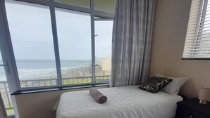 A hotel room with two beds, a view of the sea, and a balcony. - Lovely 3 Bedroom With Full sea View, Restaurants, (East London)