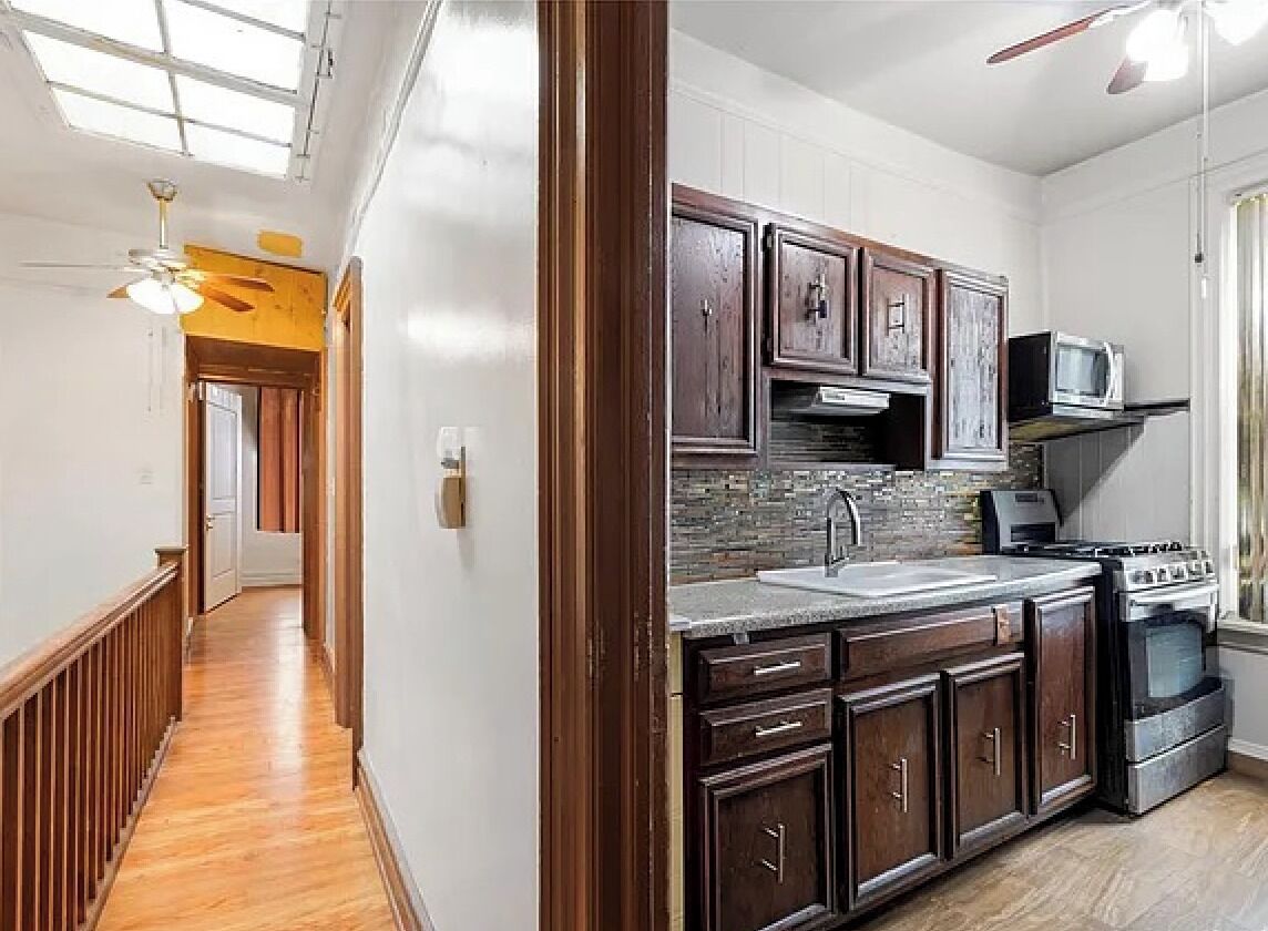 A kitchen with wooden cabinets, a microwave, and a stove.