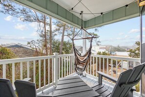 A porch with a hammock, chairs, and a view of the surrounding area. - Updated Condo with pool within walking distance to beach (North Myrtle Beach)