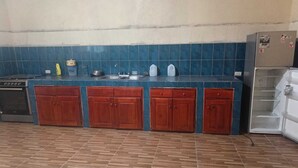 Una cucina con piastrelle blu sul retro, mobili in legno e un lavello in acciaio inossidabile.