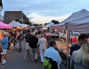 Ein belebter Markt im Freien mit verschiedenen Ständen und Zelten.