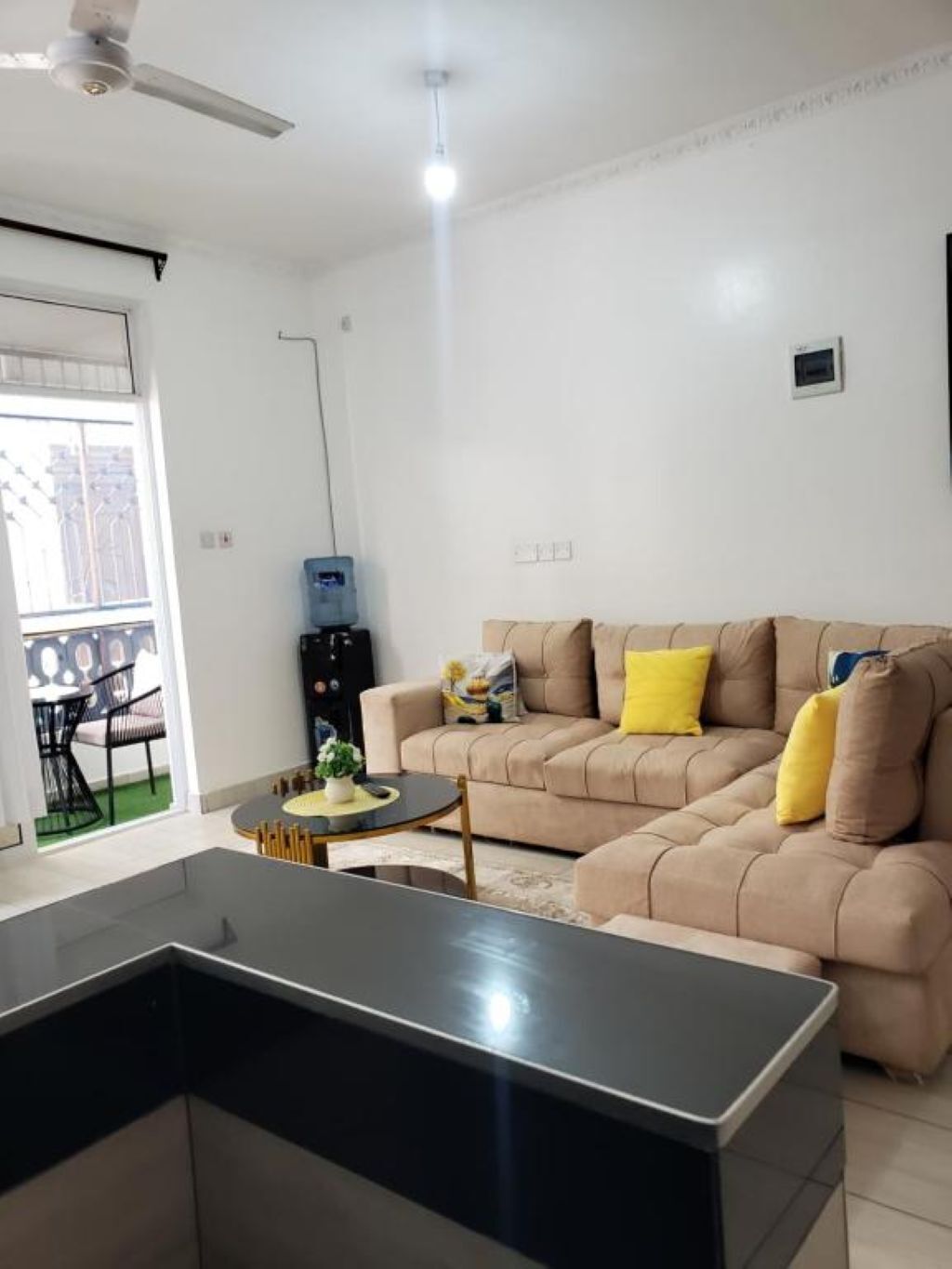 A modern living room with a sofa, a coffee table, and a dining area with chairs.