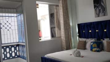 Une chambre à coucher avec un lit, un ventilateur de plafond, une fenêtre avec des rideaux et une vue sur l’extérieur.