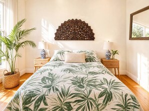 Une chambre à coucher comprenant un lit, deux tables de chevet, un élément décoratif fixé au mur et une plante en pot.