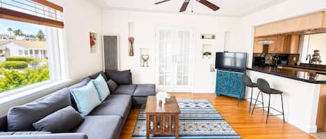 A modern living room with a grey sofa, a coffee table, and a patterned rug.