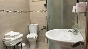 A bathroom with a toilet, bidet, and sink.