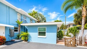 A blue building with a small porch, a utility box, and a wooden fence. - Sweet SUITE on St. Pete Beach -- Perfect for your Beach Getaway (St. Pete Beach)