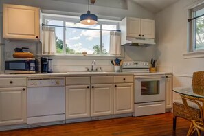 A kitchen with white cabinetry, a dishwasher, a stove, and a window with curtains. - Hidden Gem: Private 650sq ft Studio, Free Parking, Pool, Walkable, Near Downtown (St. Augustine)