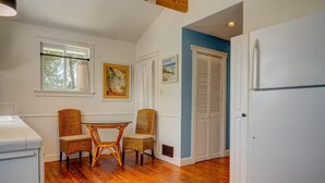 A kitchen with a dining table and chairs, wooden flooring, a white refrigerator, and a blue accent wall. - Hidden Gem: Private 650sq ft Studio, Free Parking, Pool, Walkable, Near Downtown (St. Augustine)