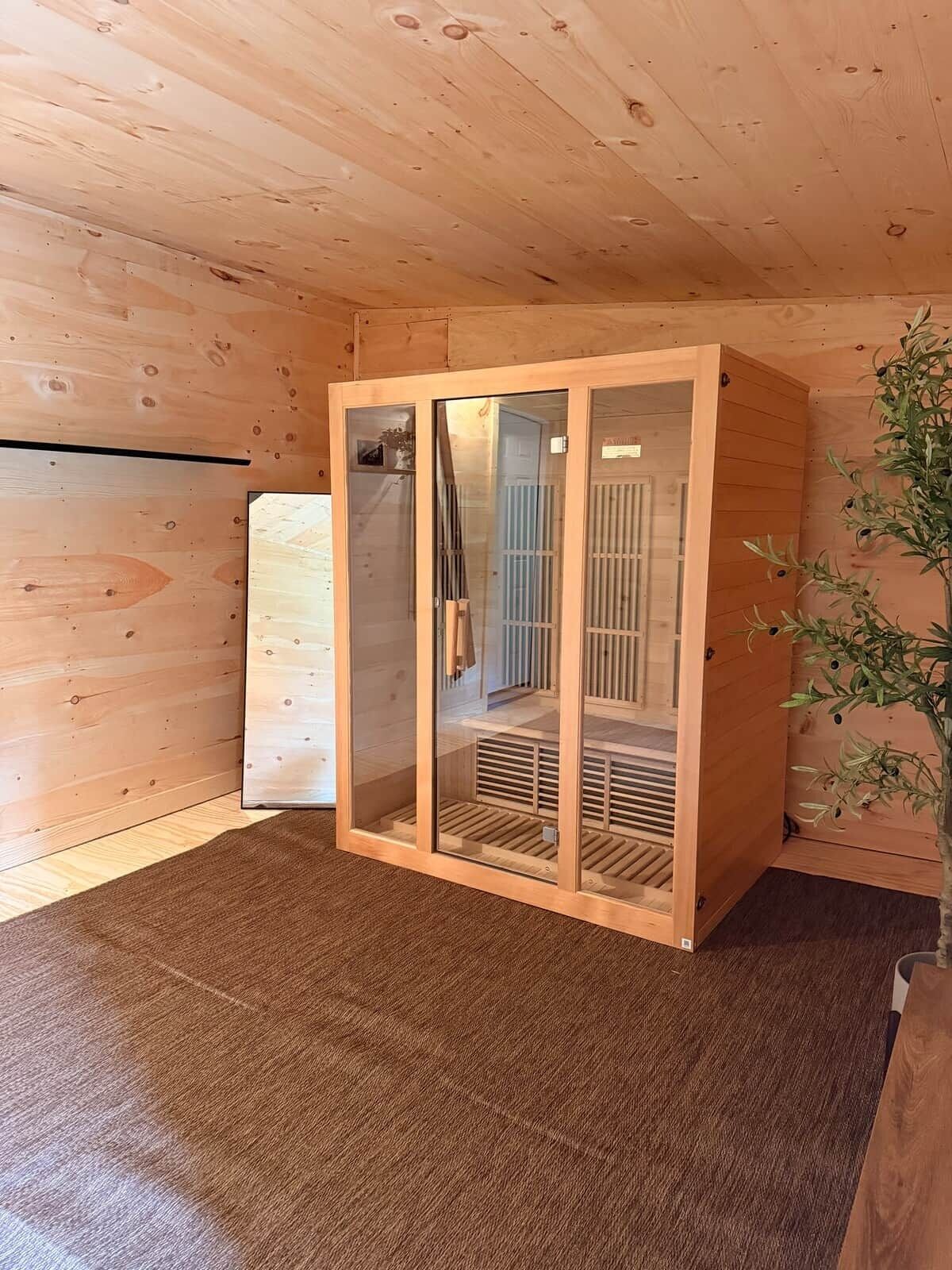 Quarto de madeira com um armário de vidro, um radiador e uma planta.