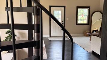 A modern interior with a dark wood staircase leading to a living area.