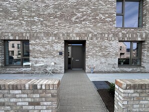 A modern building with a brick facade, a central entrance, and a small outdoor seating area. - 2027 Open championship in St Andrews (St Andrews)