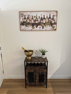 A wooden table with a wine bottle, a glass, and a plant. - 2027 Open championship in St Andrews (St Andrews)