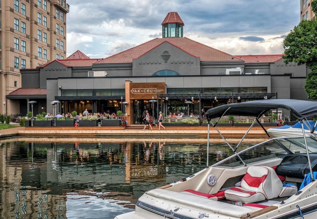 Un hôtel situé au bord de l’eau, doté d’un espace extérieur couvert avec des sièges et d’un quai pour bateaux.